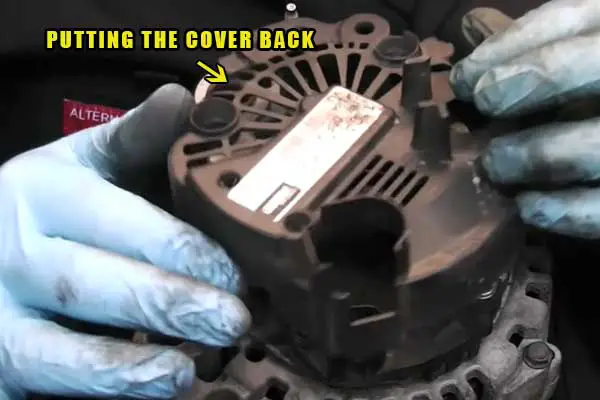 putting the cover back of alternator in the car